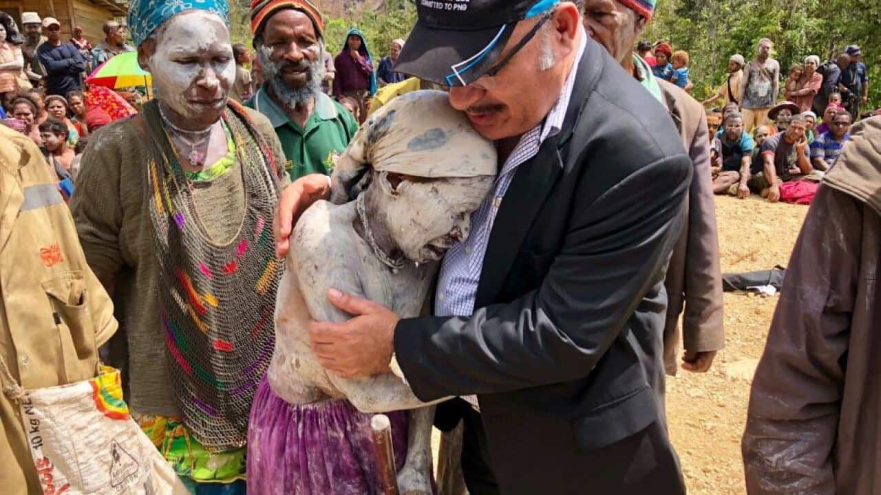 PNG PM comforts woman following 2018 earthquake