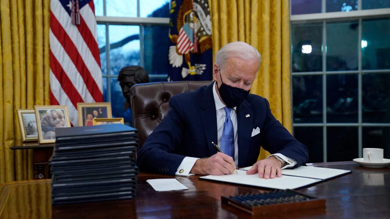 President Joe Biden signs his first executive orders in the Oval Office of the White House on Wednesday, Jan. 20, 2021, in Washington. (AP Photo/Evan Vucci)