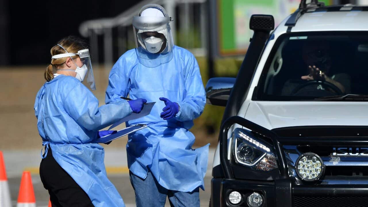 Healthcare workers are seen testing people at a pop-up COVID-19 testing centre at St Thomas More College in Brisbane on 11 September 2021.