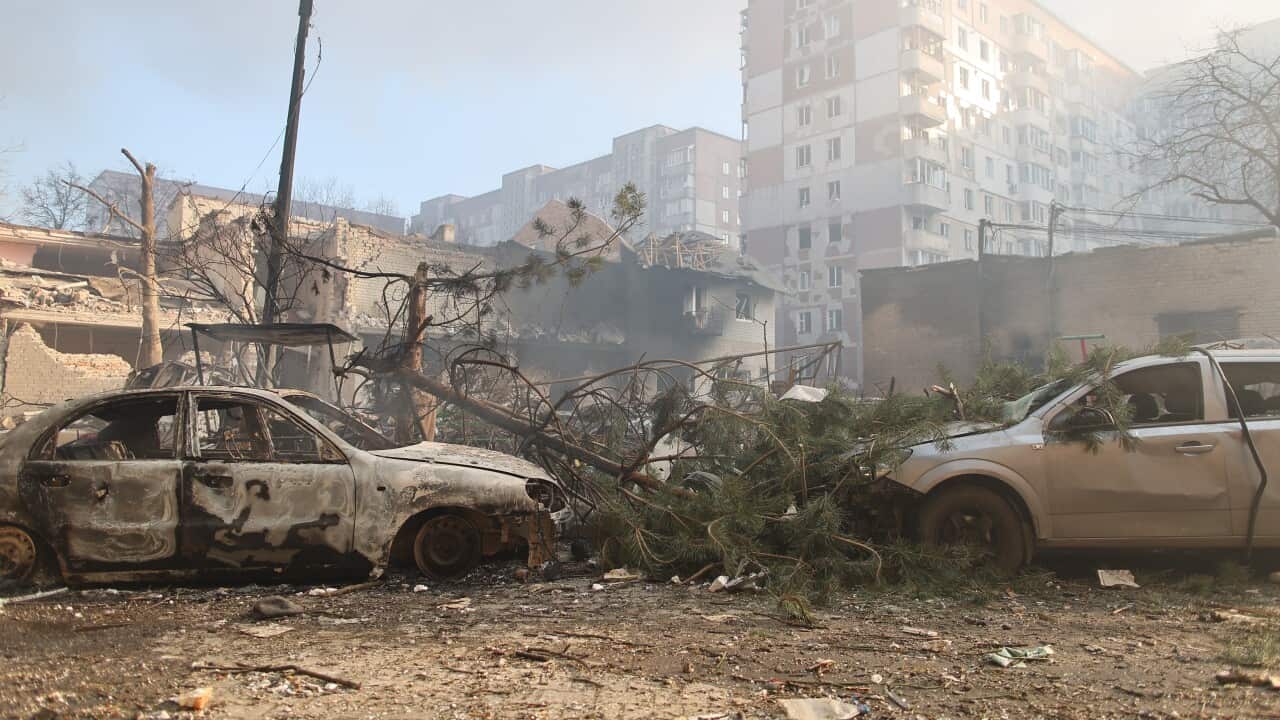 Burnt out cars in front of burnt and damaged buildings