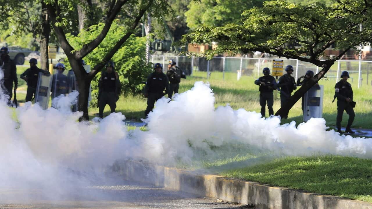 Venezuelan Bolivarian National Guard officers fire teargase towards resident that try to walks to the Military base Paramacay in Valencia, Venezuela.