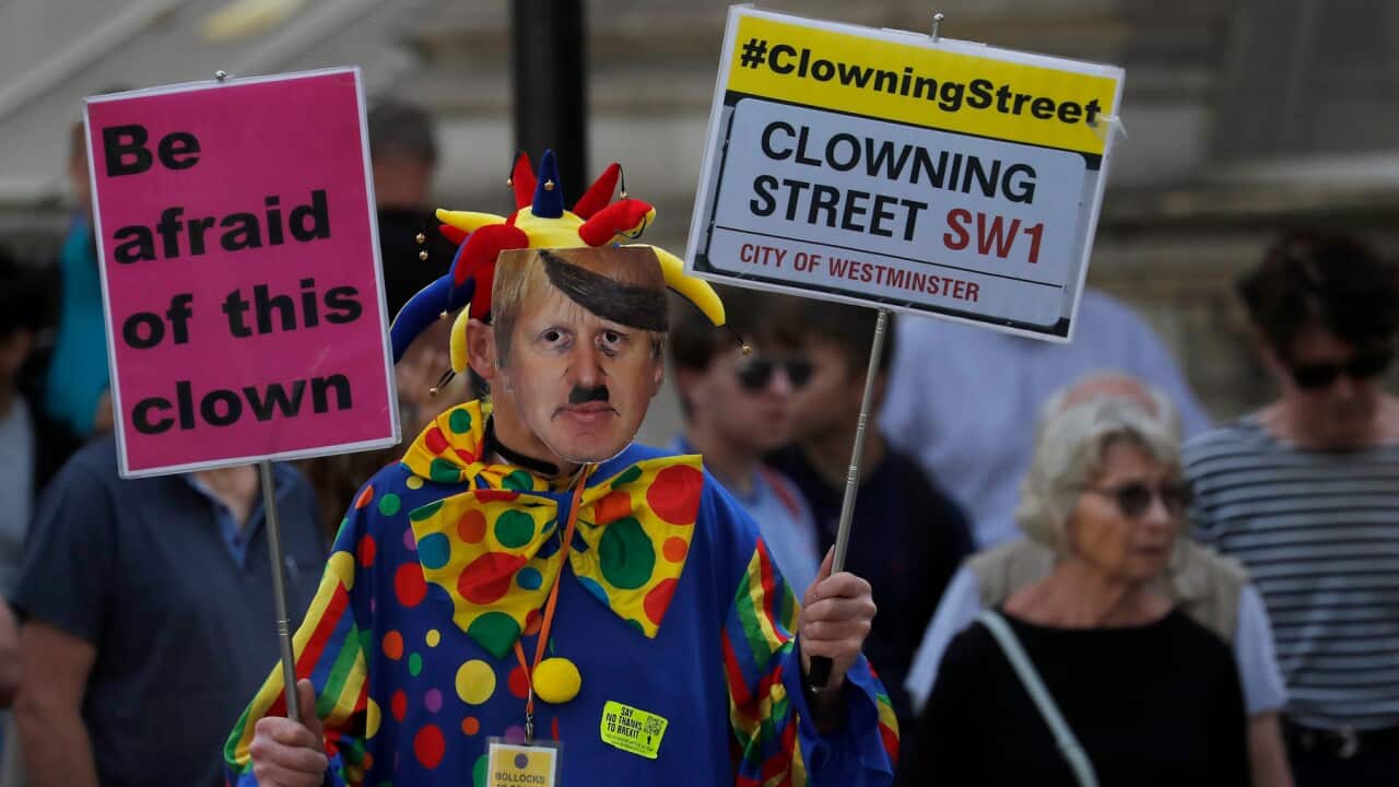 A man dressed as a clown and wearing a Boris Johnson mask protest in front of the Downing Street gate in London, Thursday, Aug. 29, 2019. Political opposition to Prime Minister Boris Johnson's move to suspend Parliament is crystalizing, with protests arou