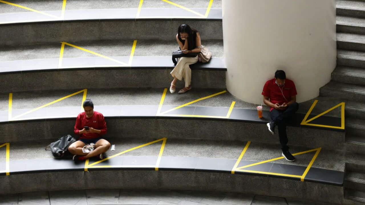 People rest in areas marked for safe distancing as authorities try to combat the spread of the COVID-19 pandemic on April 2, 2020 in Singapore.