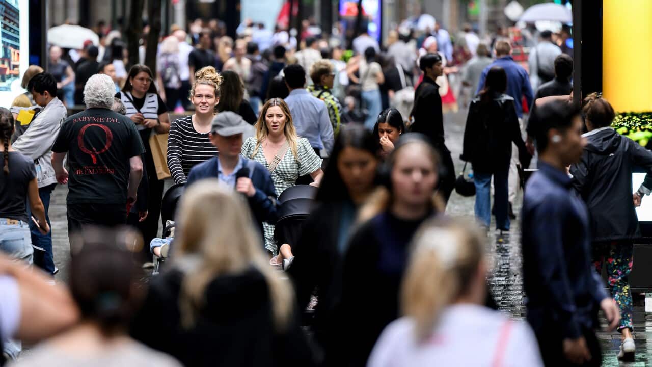 A crowd of people walking on a busy street.