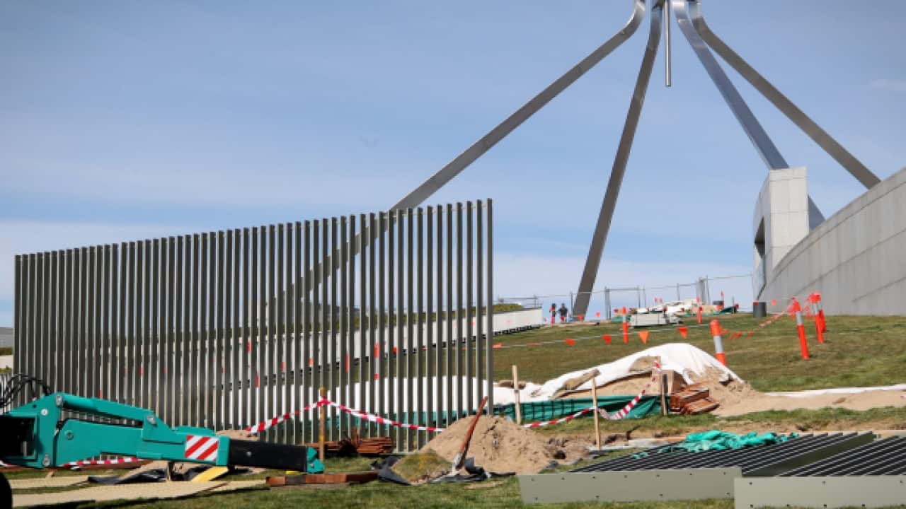 A security fence is installed across the lawns of Parliament House in Canberra.