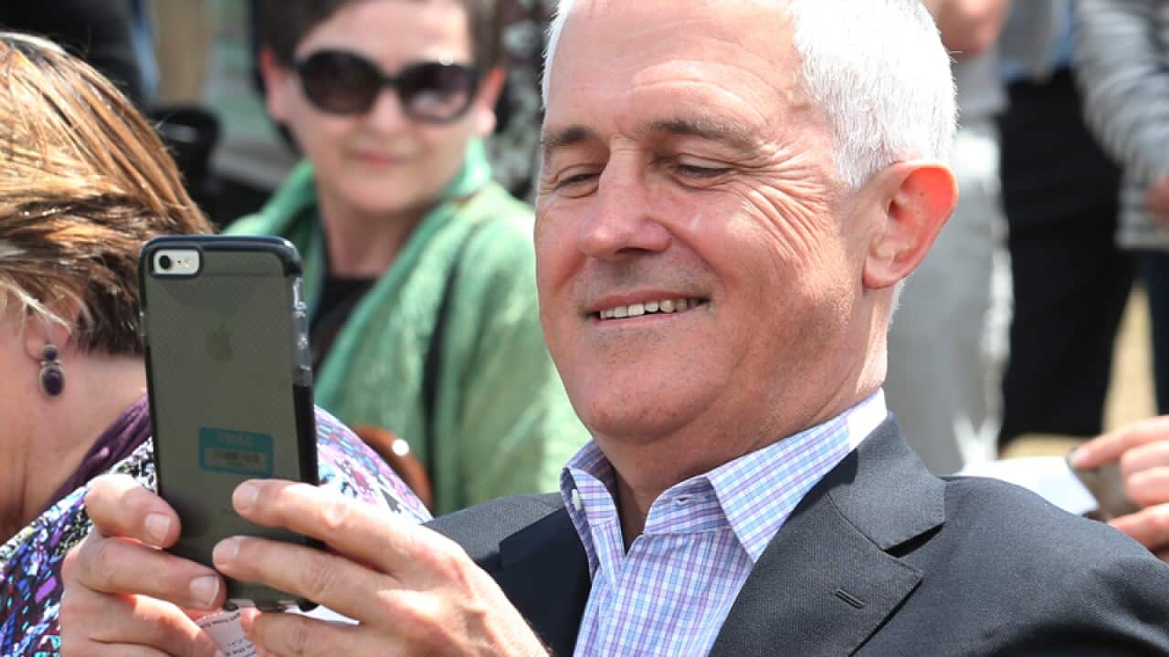 Prime Minister Malcolm Turnbull takes a photograph with his phone
