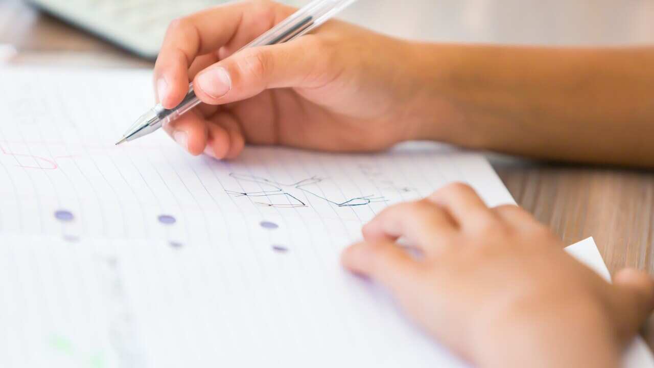 Young boy drawing on exercise book