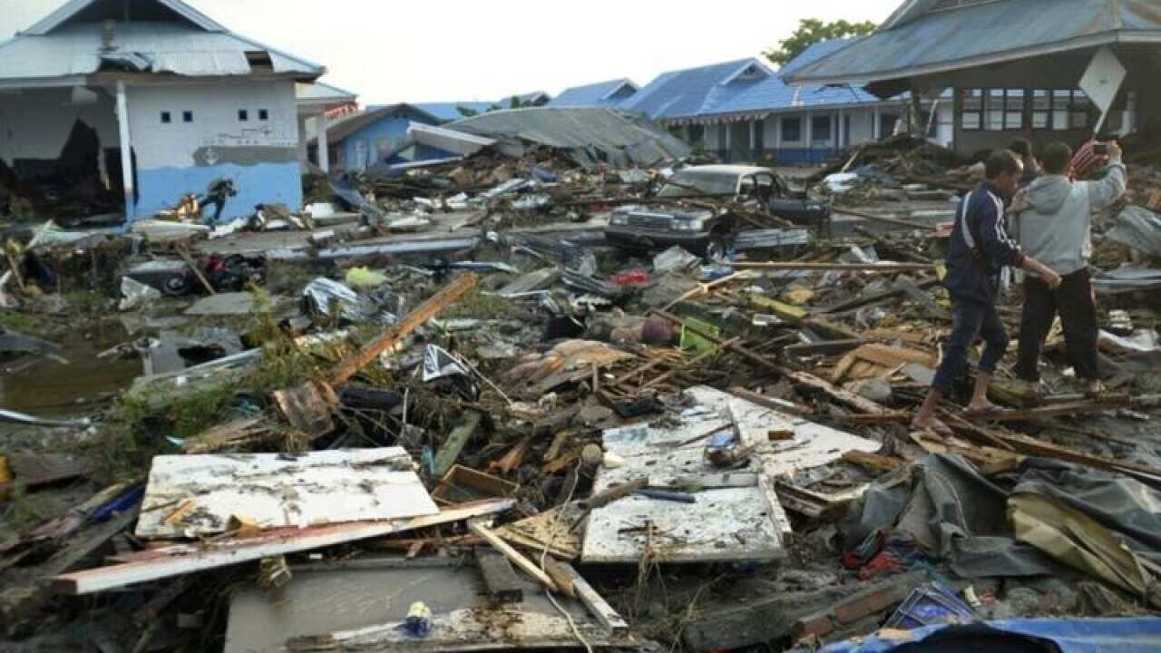 Indonesian men survey damage after earthquakes and a tsunami in Palu.