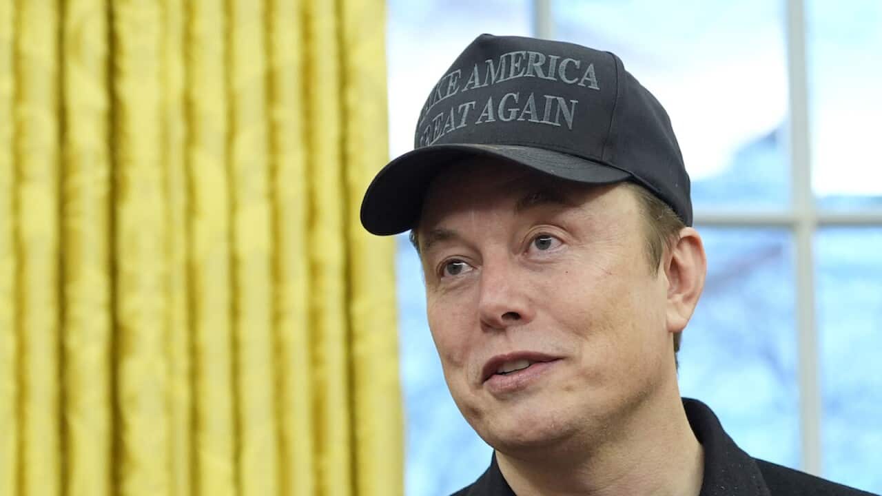 Elon Musk is wearing a cap with the words "Make America Great Again".