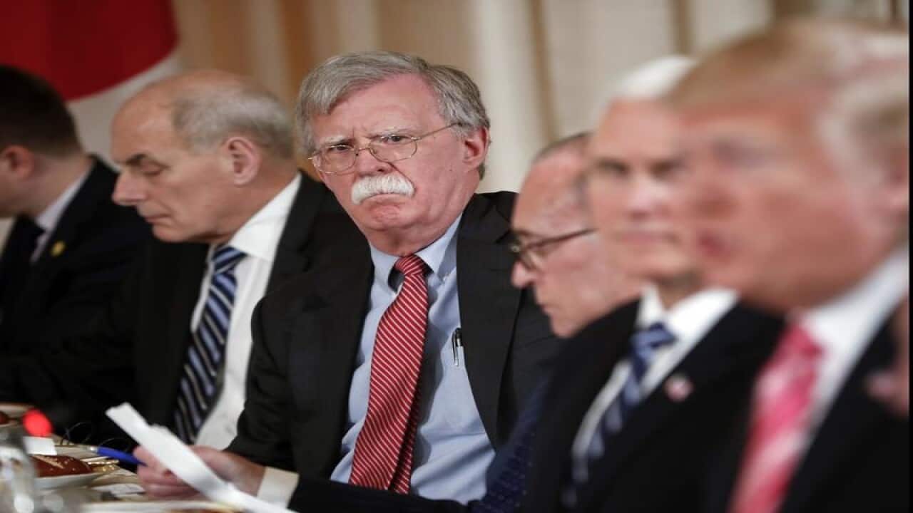 National security adviser John Bolton listens as the president talks