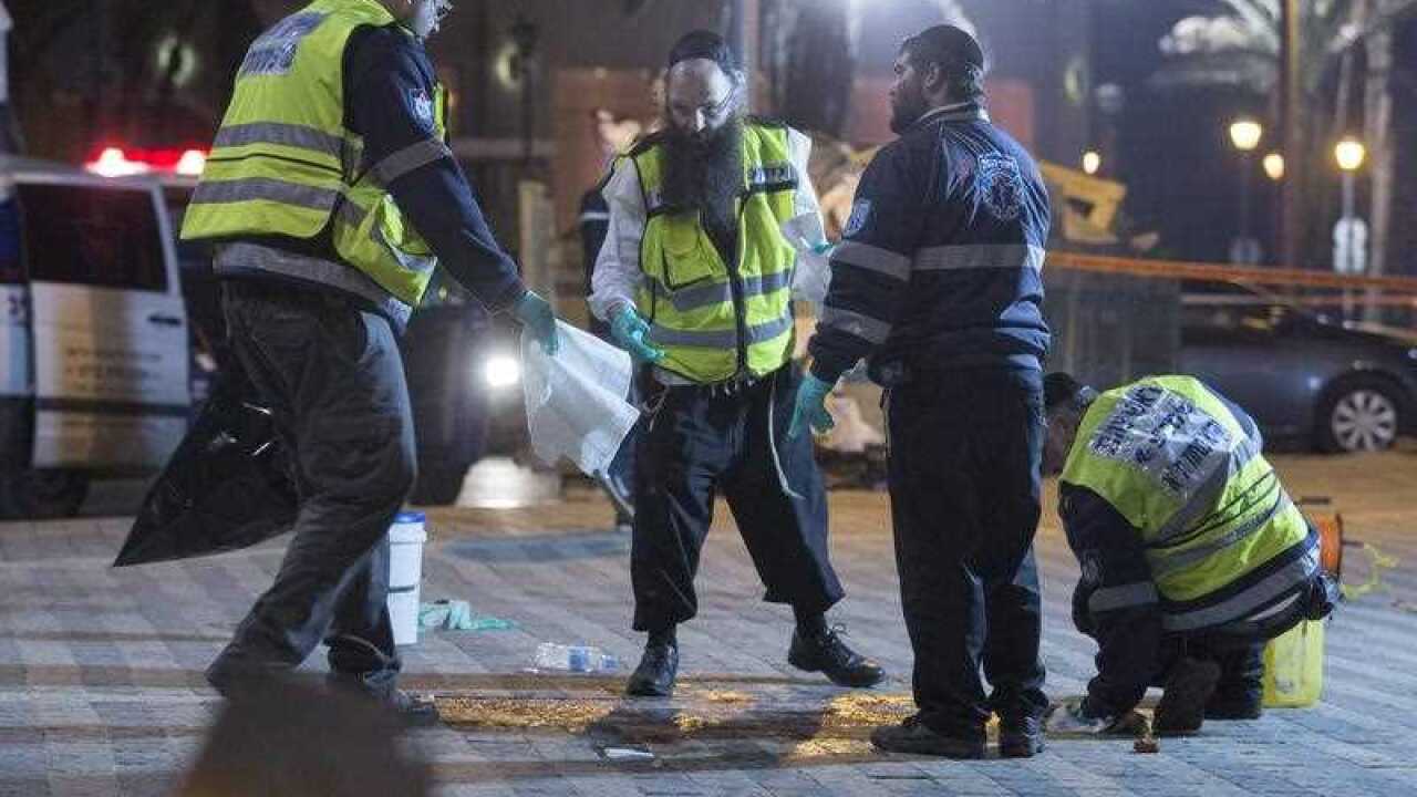 An ultra-Orthodox Jewish burial society cleaning up blood and medical bandages at the scene a stabbing attack on a sea side walking area in old Jaffa