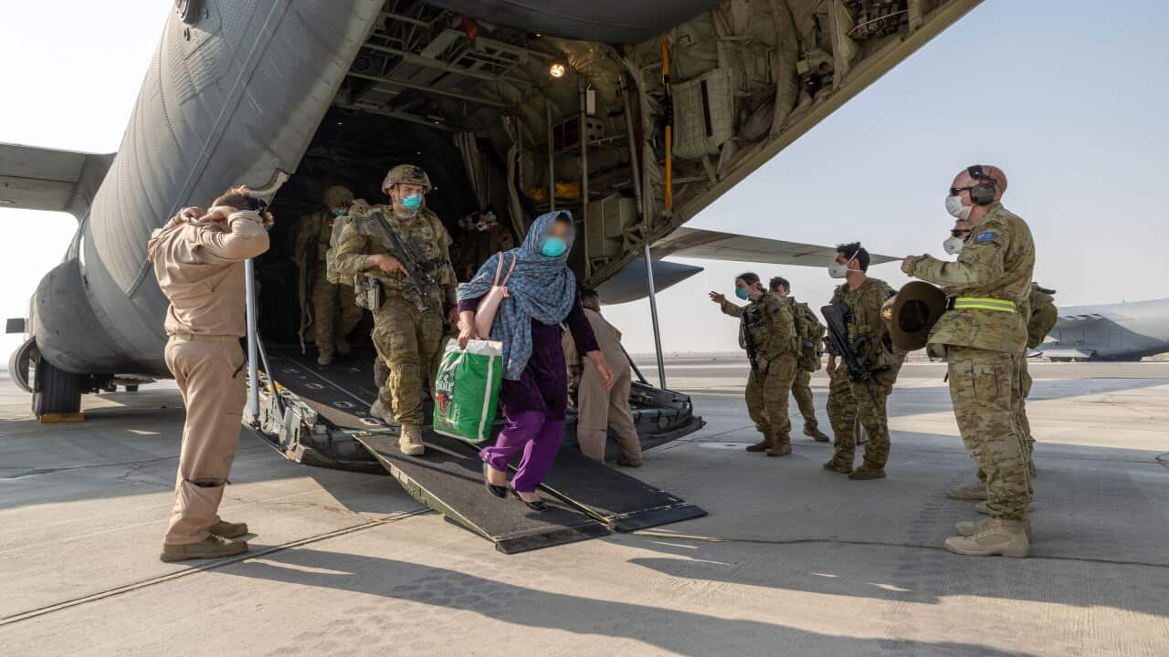 A supplied image from Friday, August 27, 2021, shows Afghanistan evacuees and soldiers disembarking at a base.