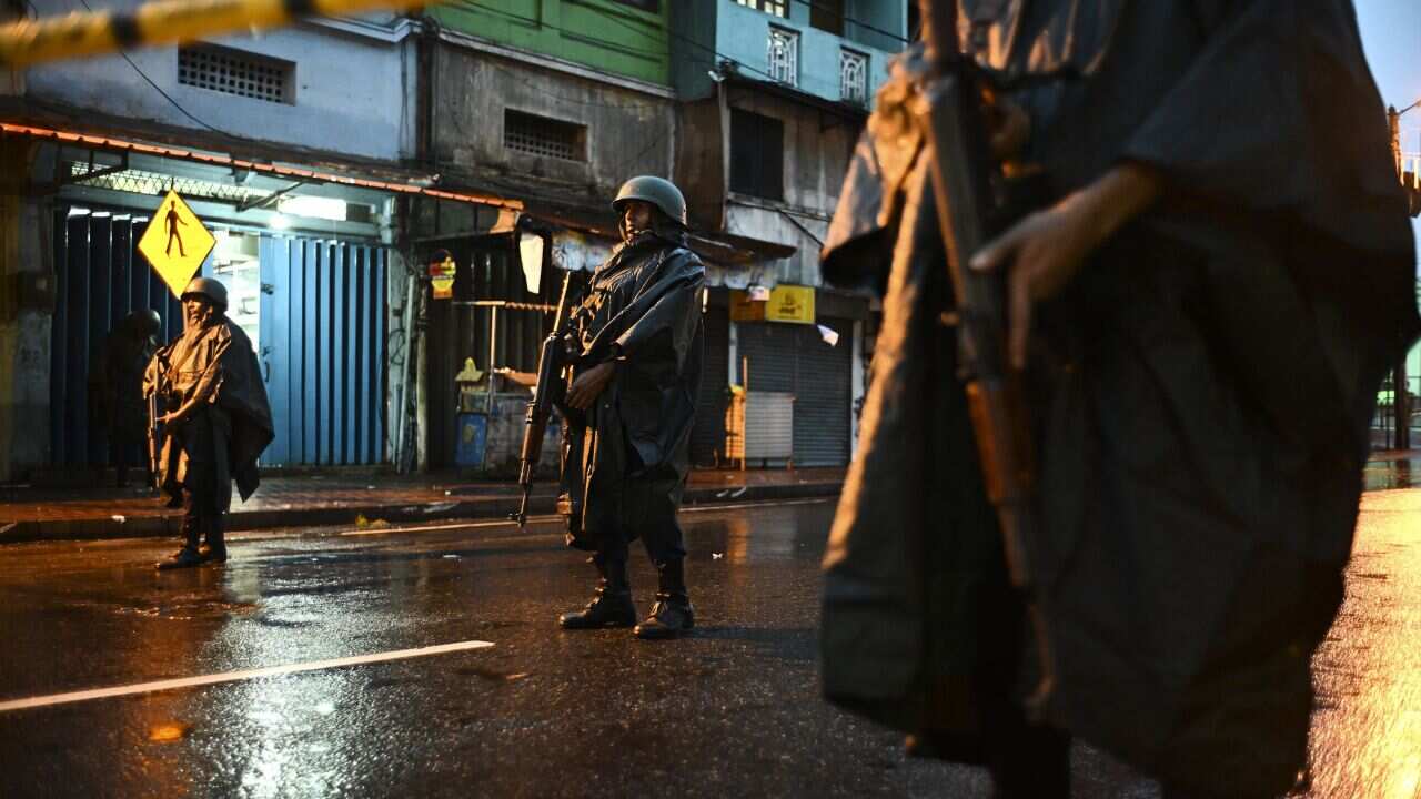 Sri Lankan soldiers stand guard under the rain at St. Anthony's Shrine in Colombo on April 25, 2019