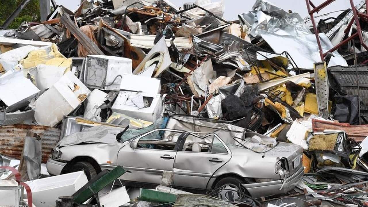 A car is seen amongst waste at a metal recycling business in Brisbane