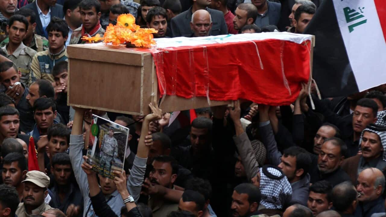 Iraqis carry the coffin of a member of the Shiite militia, Baghdad