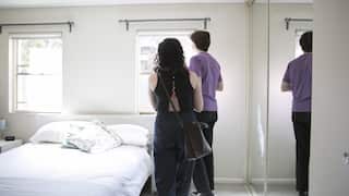 Two people inspecting a bedroom.