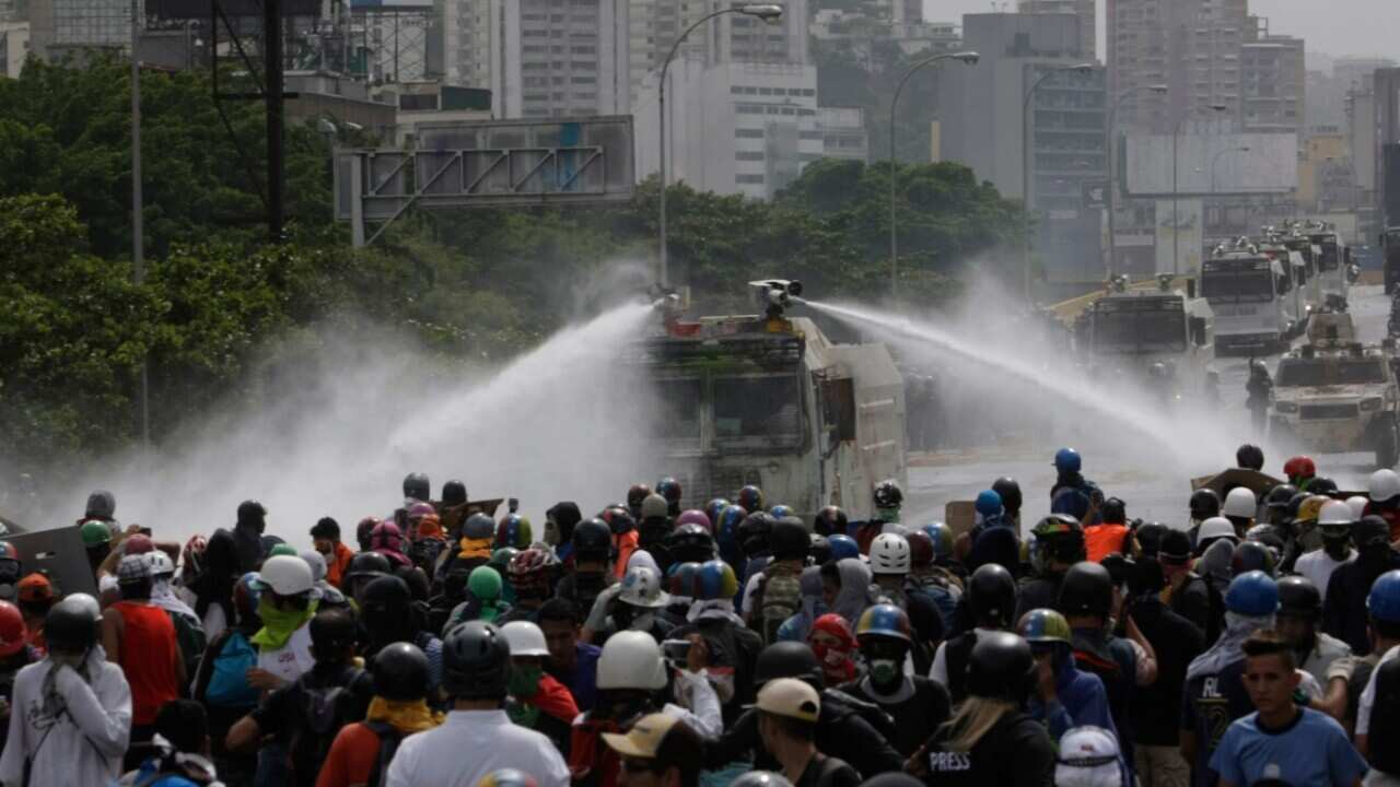 Security forces spray demonstrators with water canons during an anti-government protest