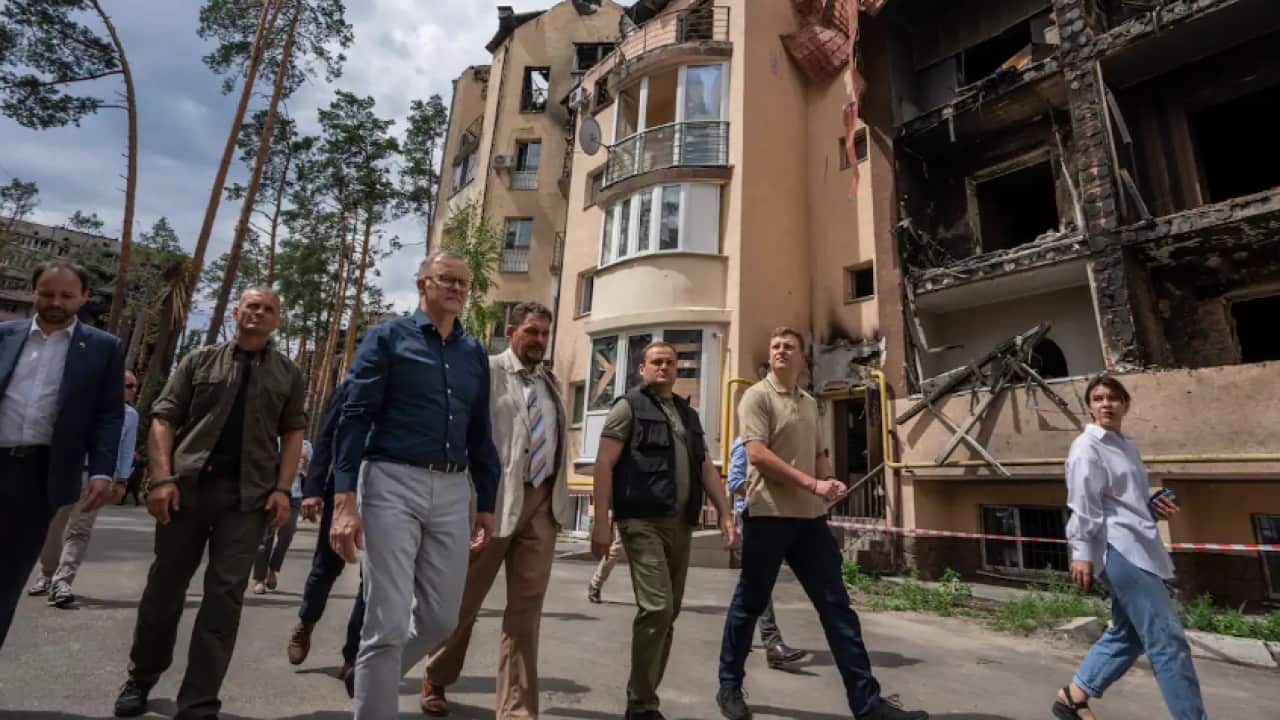 Australian Prime Minister Anthony Albanese, third left, looks at apartment buildings damaged by Russian shelling, during his visit to Irpin, on the outskirts of Kyiv, Ukraine, Sunday, 3 July, 2022.