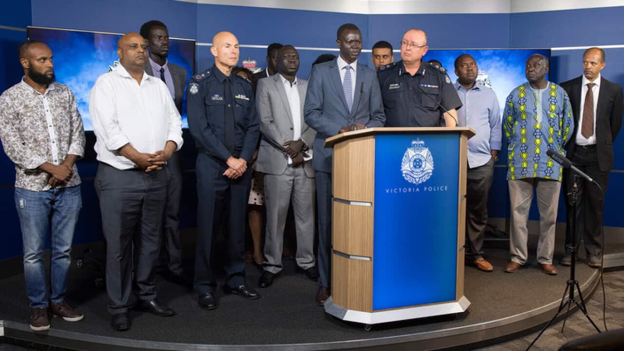 An African community leaders speaks to the media and Victorian Chief Police Commissioner Graham Ashton during a press conference