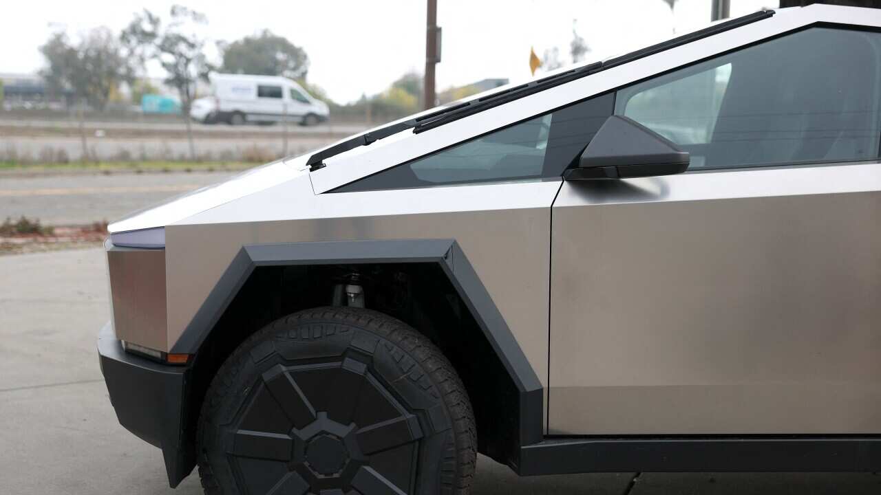 A Tesla Cybertruck is displayed at a dealership.