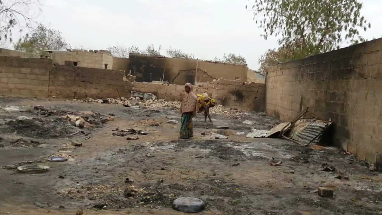 A young girl stands amid the burned ruins of Baga, Nigeria