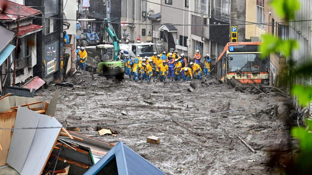Rescuers work as they conduct a search operation at the site of a mudslide in Atami, Shizuoka prefecture, Sunday, July 4, 2021