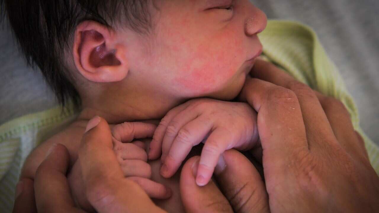 A mother holds her newborn baby