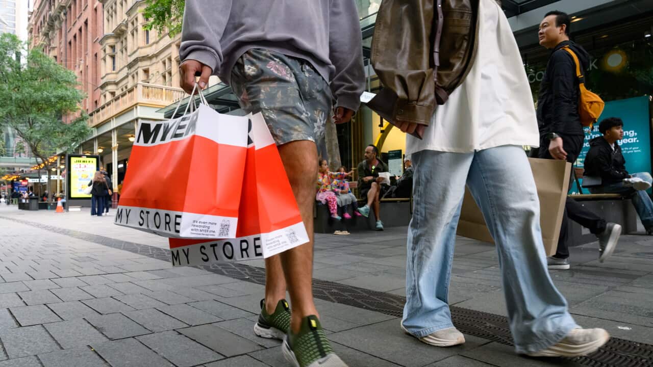 Shoppers walking through a busy urban shopping district.