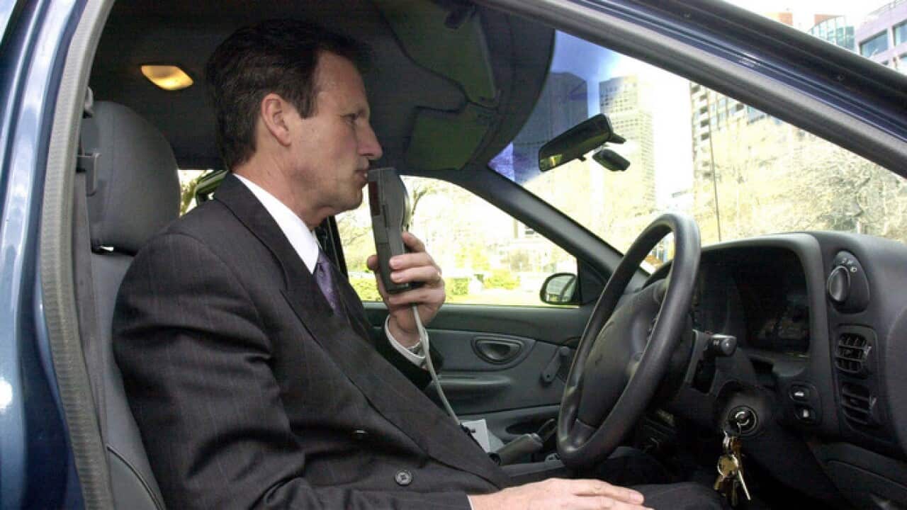 Co-developer of the alcohol ignition interlock device Rod Tatersall illustrates the use of the mini-machine(AAP)