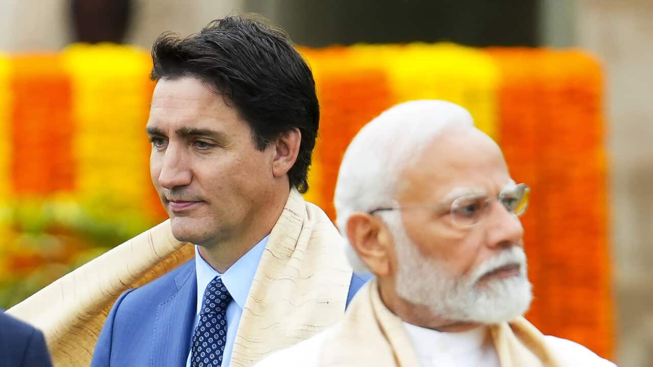 Justin Trudeau in a suit alongside Narendra Modi in traditional wear.