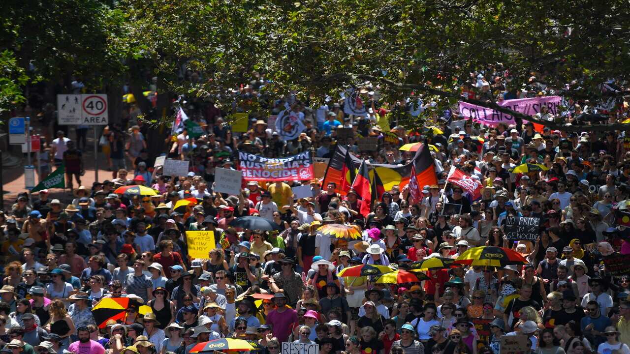Protestors march down Pitt Street during an Invasion Day rally in Sydney, Sunday, January 26, 2020. (AAP Image/Paul Braven) NO ARCHIVING