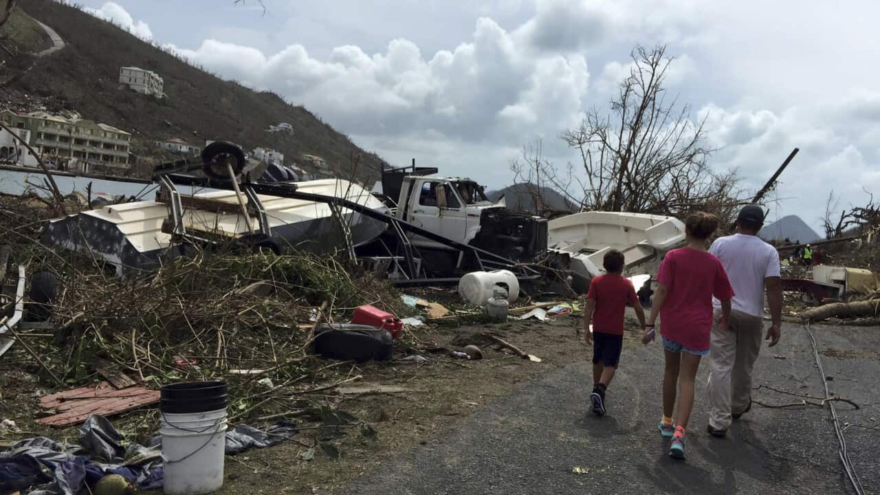 people walk near debris in the aftermath of Hurricane Irma in Tortola, in the British Virgin Islands