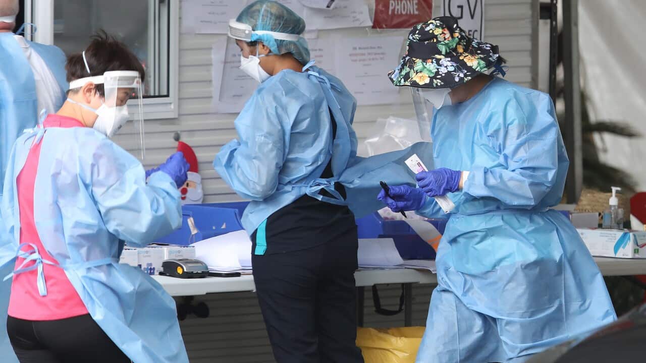 Health workers attend a Covid19 testing site in Brisbane, Friday, January 7, 2022. Queensland has recorded 10,953 new COVID-19 cases as the state considers delaying the return of primary school students to class. (AAP Image/Jono Searle) NO ARCHIVING