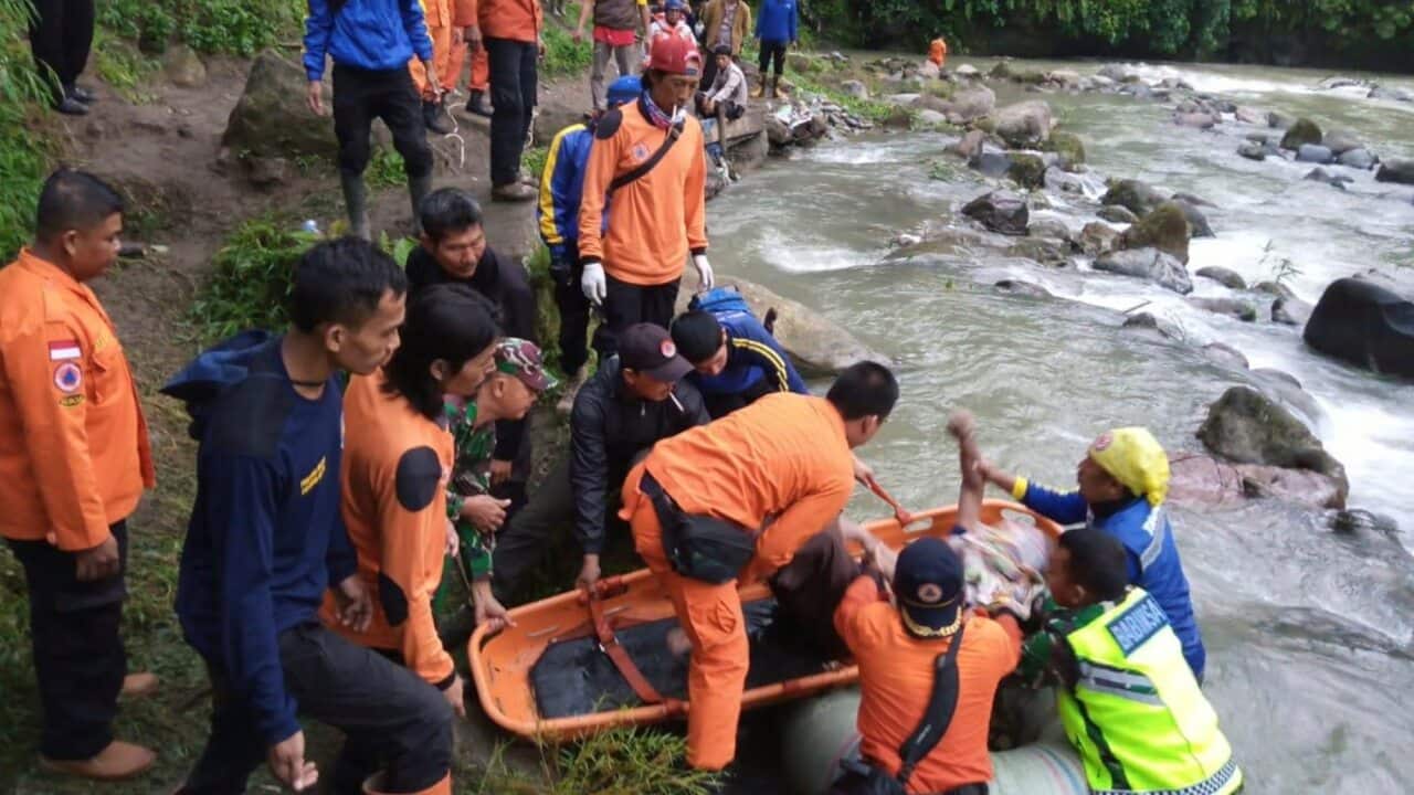 Rescuers remove the body of a victim of the bus accident in Pagaralam, Indonesia.