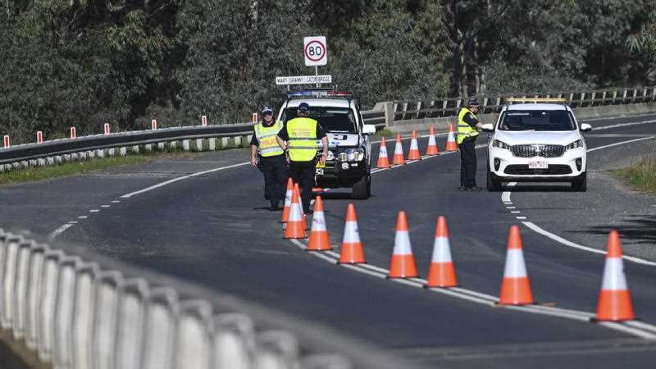 NSW Police officers are seen at the NSW-Victoria border crossing in Howlong near Albury, NSW.