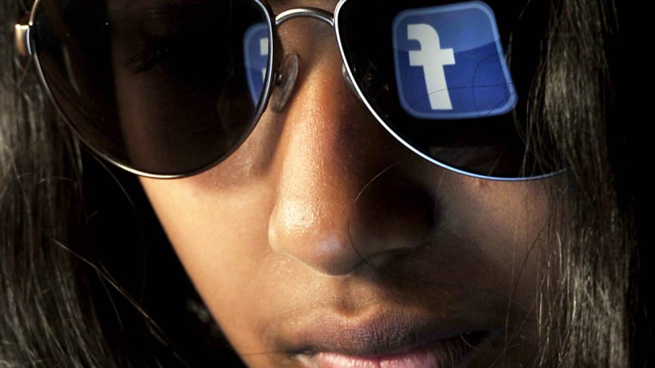 The Facebook logo is reflected in a pair of sunglasses
