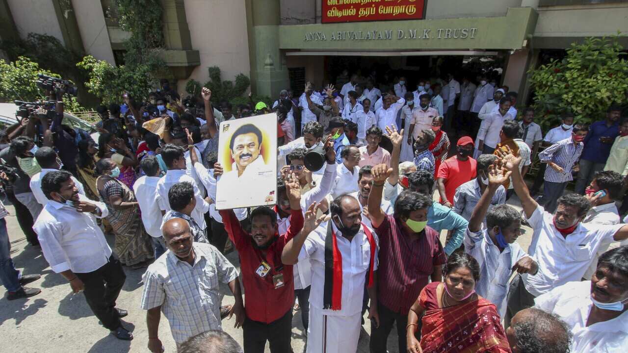 Dravida Munnetra Kazhagam (DMK) party cadres display a photograph of their leader M.K. Stalin as they celebrate early leads for the party in the Tamil Nadu state assembly elections in Chennai, India, Sunday May 2, 2021. (AP Photo/R. Parthibhan)