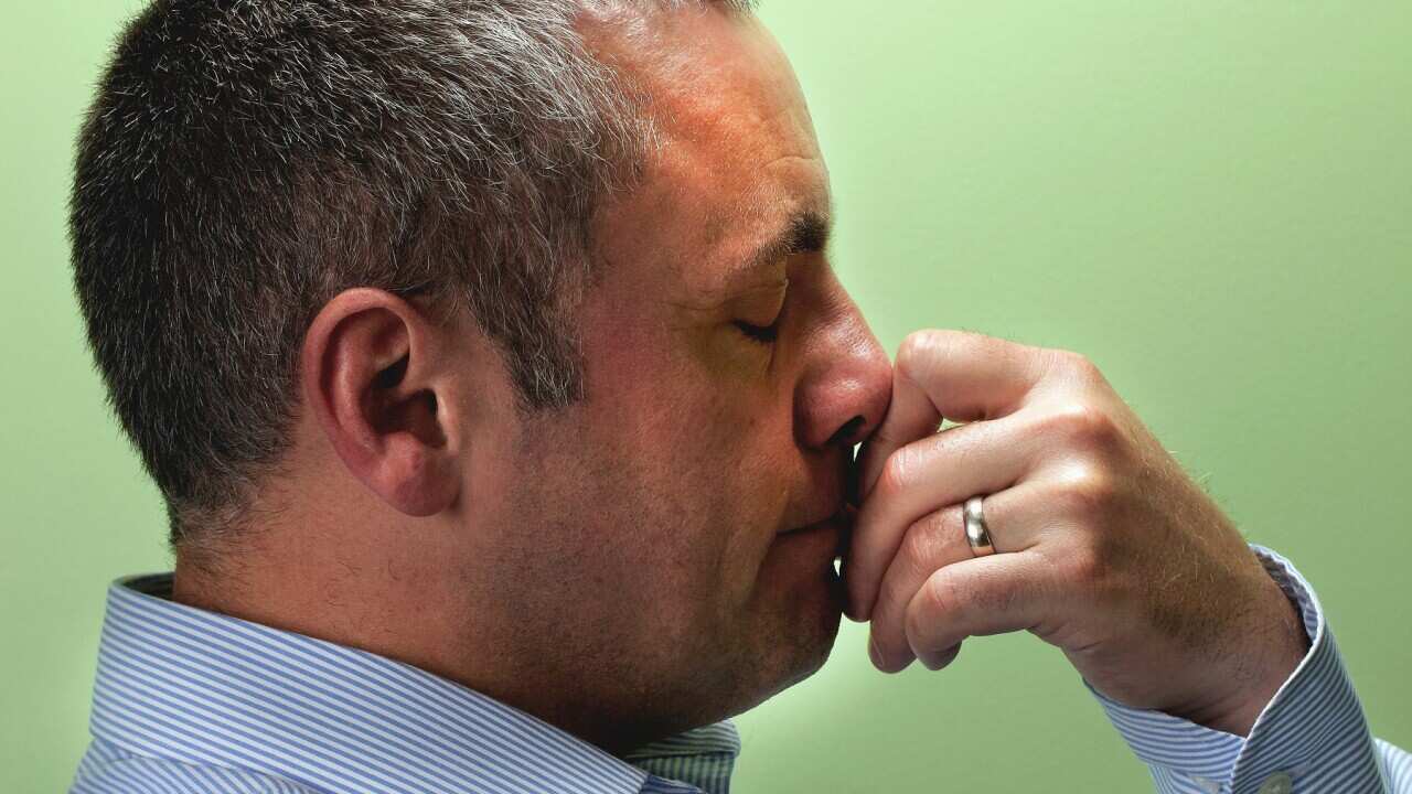 Mature male teacher with hand on chin