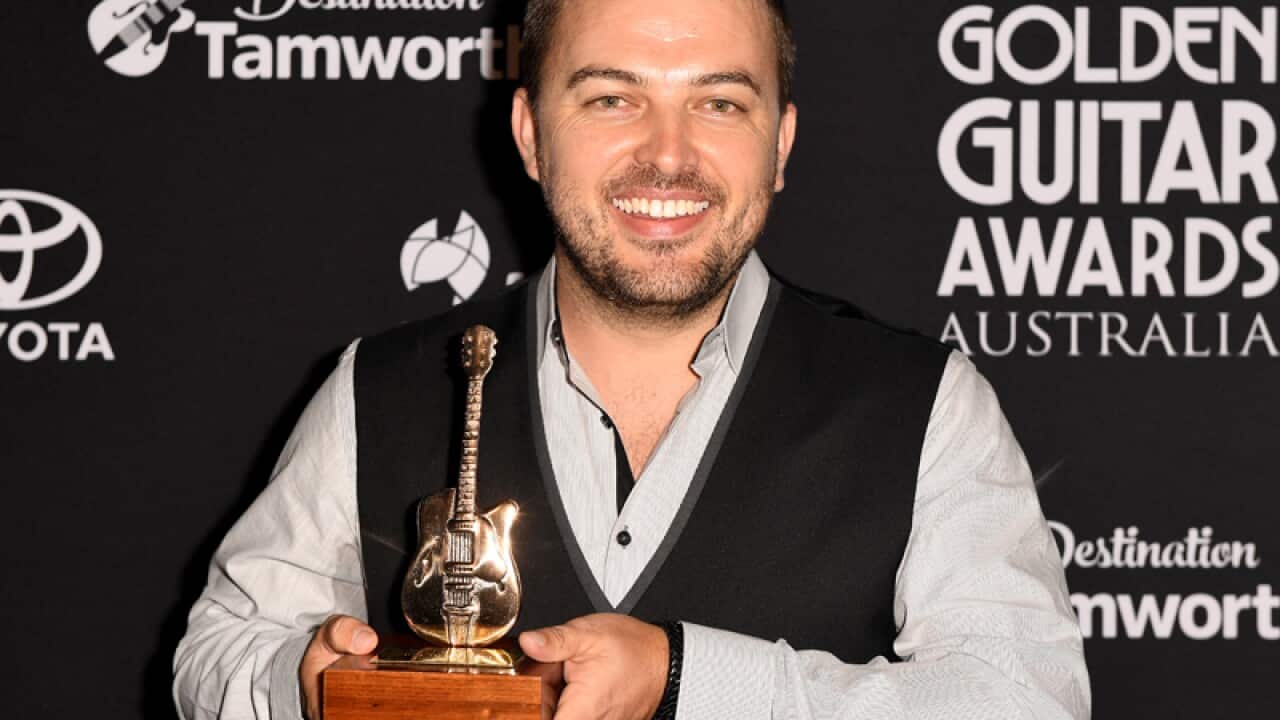 Travis Collins poses for a photograph