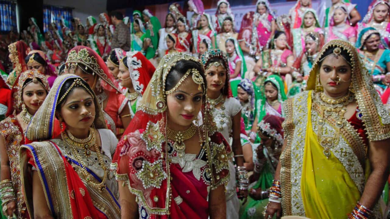 In this file photo, Indian brides leave after a group photo.