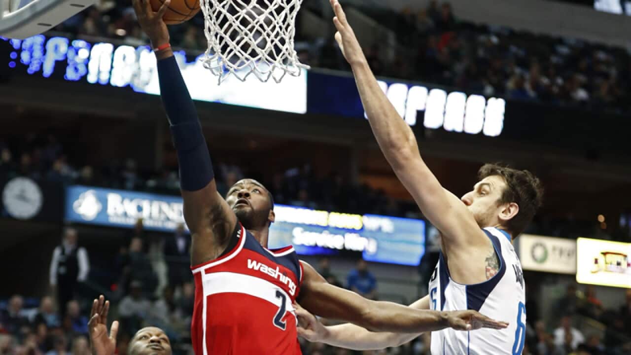 Wizards guard John Wall (C) and Dallas Mavericks player Andrew Bogut