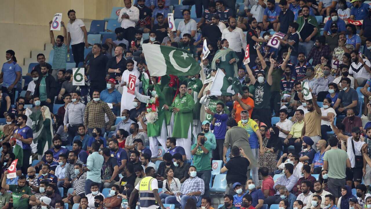 Pakistan's cricket fans celebrate a six by captain Babar Azam during the Cricket Twenty20 World Cup match between India and Pakistan in Dubai, UAE, Sunday, Oct. 24, 2021. (AP Photo/Aijaz Rahi)