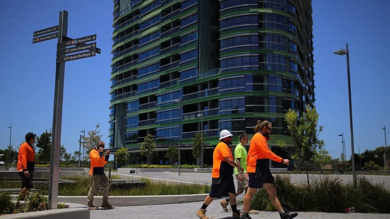Construction workers are seen in front of Opal Tower after NSW Opposition Leader Michael Daley addressed the media in Sydney.