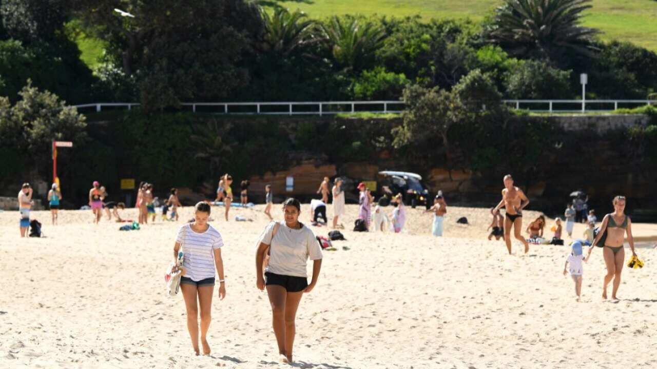 Beachgoers swimming and exercising on the sand at Coogee Beach in Sydney, Wednesday, April 22, 2020