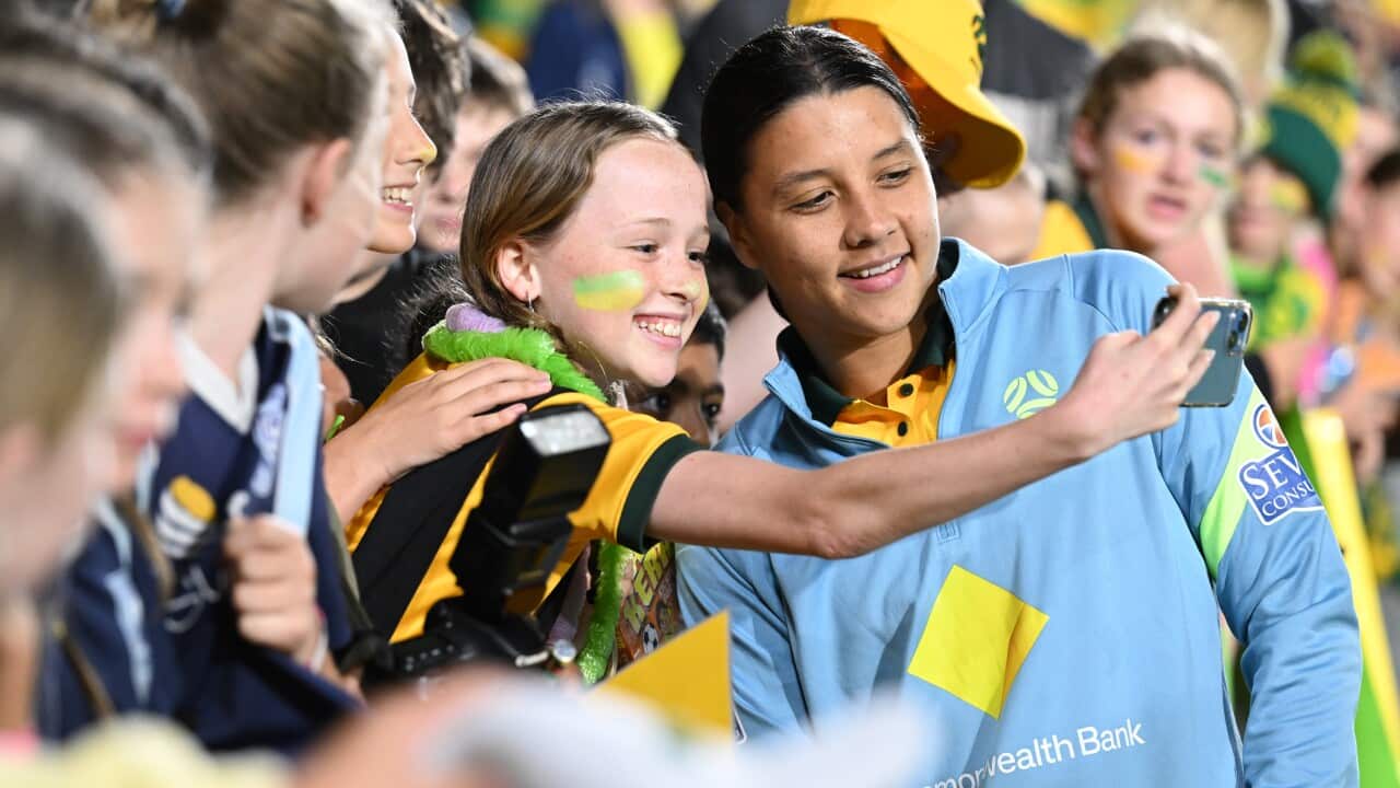 Sam Kerr signs autographs for fans.