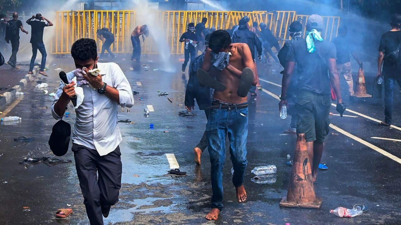 Police in vehicles using water cannon on protesters in the Sri Lankan capital of Colombo.