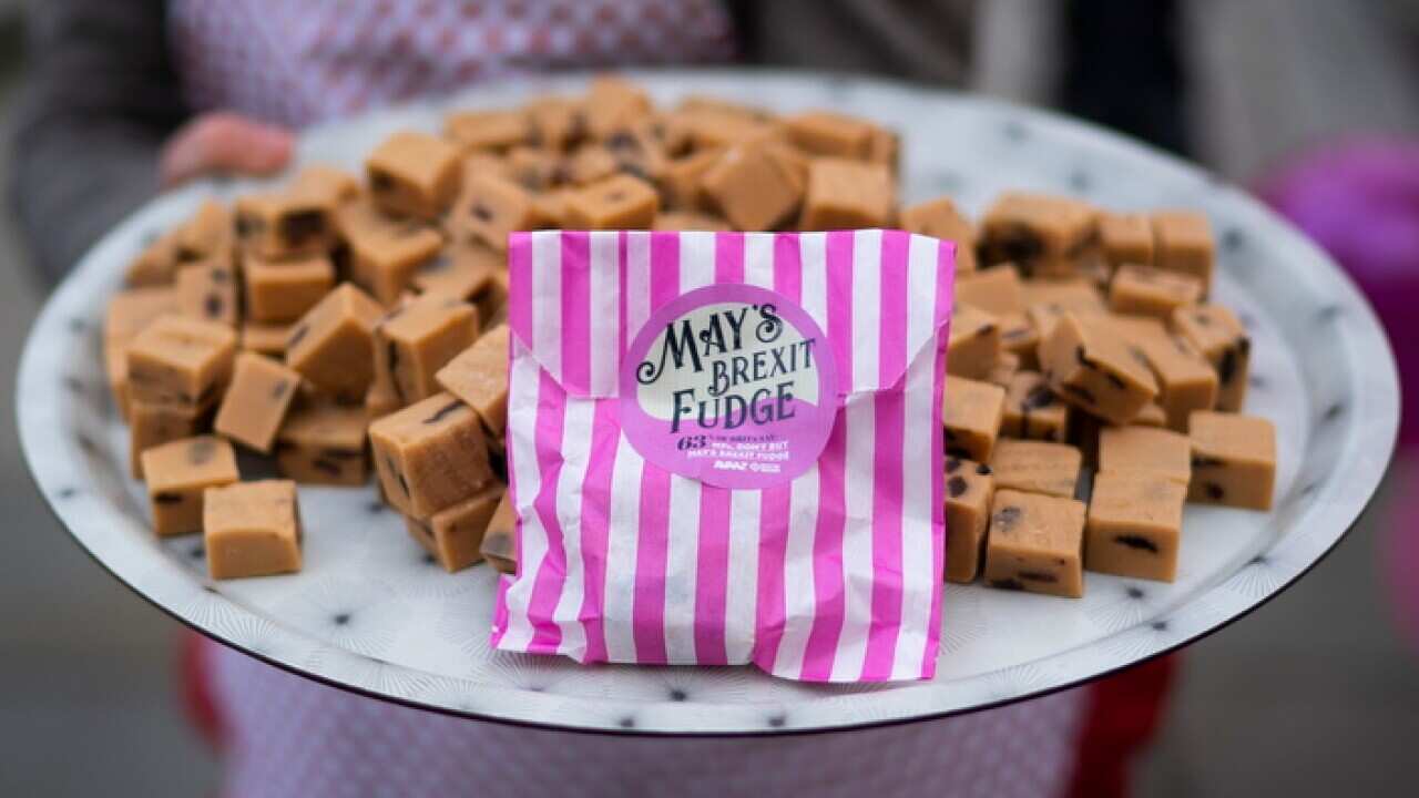 Anti-Brexit campaigner dressed as British Prime Minister Theresa May holding a plate of fudge poses for photographers outside Houses of Parliament.