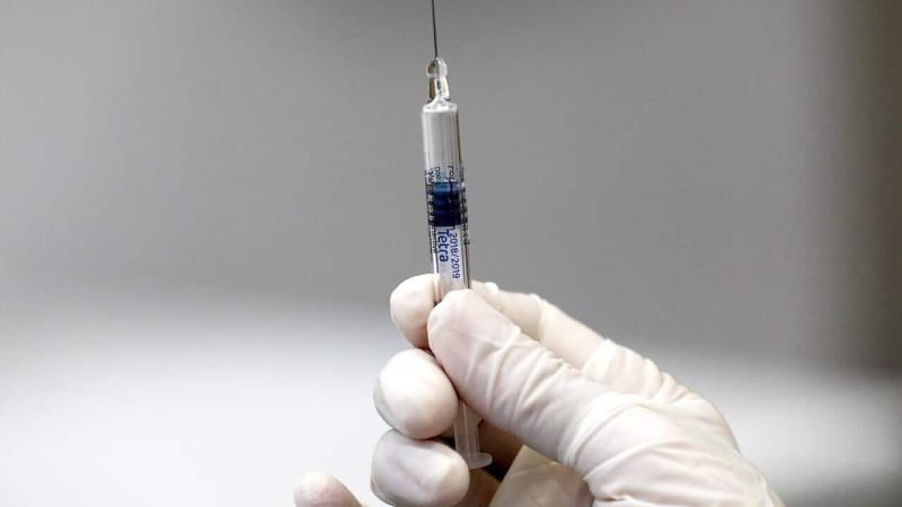 A person holds an injection with an influenza vaccine