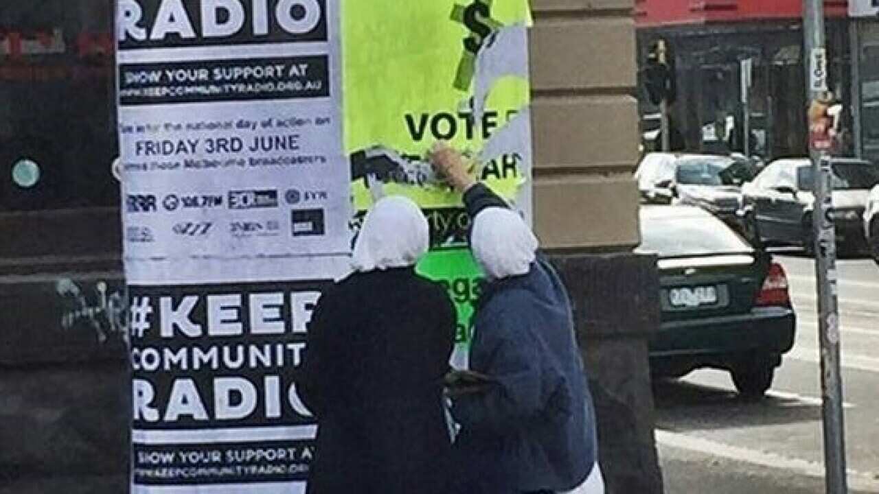 A supplied image obtained Friday, June 3, 2016 of two nuns in Melbourne appear to rip down Sex Party posters calling for churches to be taxed and marijuana to be legalised. (AAP Image/Supplied) NO ARCHIVING, EDITORIAL USE ONLY