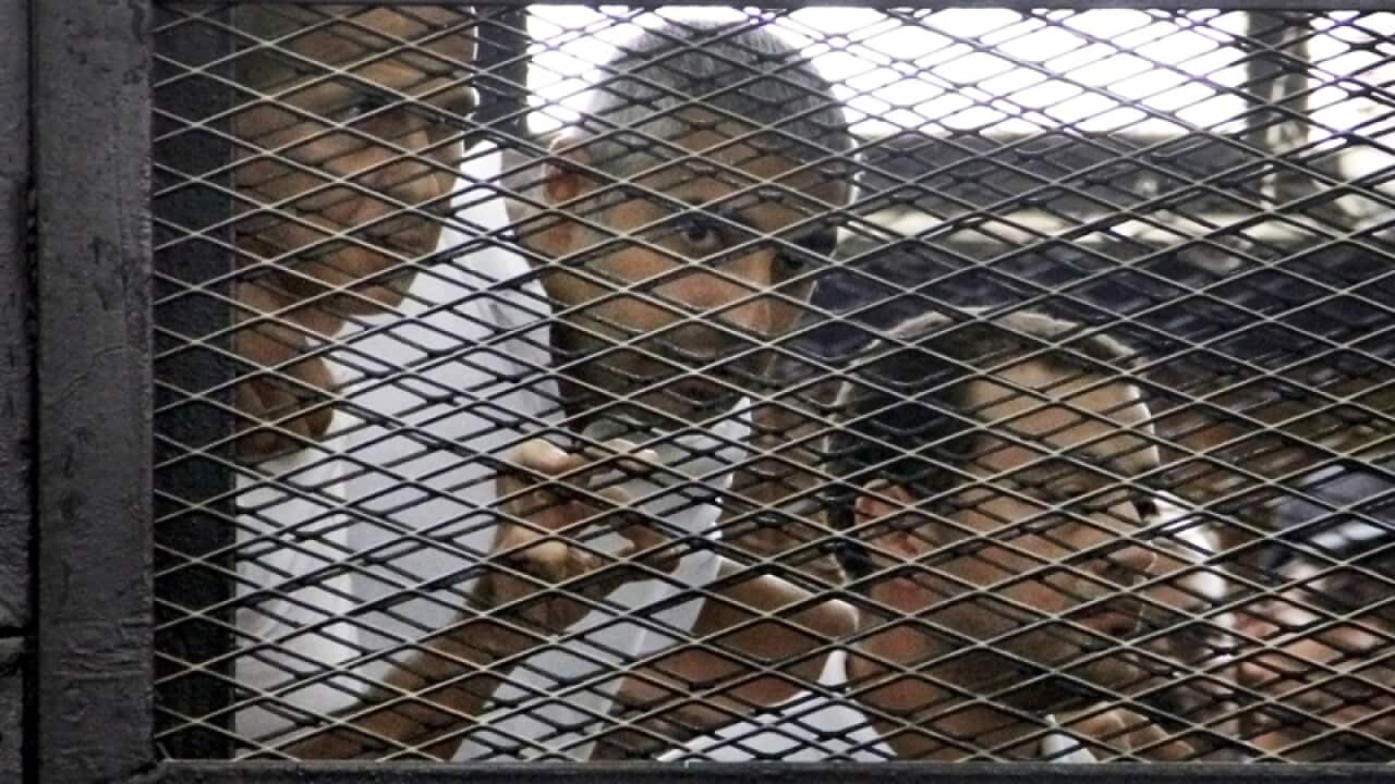 Australian Peter Greste (L) and two other Al Jazeera journalists